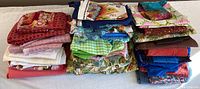Overall view of four stacks of folded fabric in various colors and prints