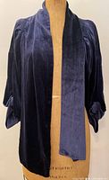 Front view of navy blue silk velvet jacket on mannequin with open front and collar.