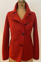Front view of red jacket with collar open, showing overall fit and three-button closure.