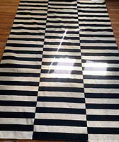 Full view of the IKEA Stockholm rug showing the black and white horizontal stripe pattern.