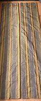 Two full-length silk curtain panels laid out to show size and stripe pattern