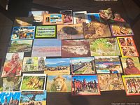 Array of assorted African postcards displayed on a surface showing various wildlife and cultural images.