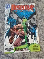 Front cover of Batman Detective Comics #599 featuring Batman and character with grotesque green appearance, 'Blind Justice' subtitle.