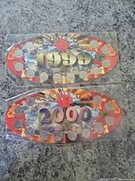 Two oval-shaped special holders containing Canadian quarters from 1999 and 2000 with colorful Canadian-themed backgrounds and maple leaf design.