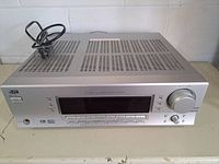 Front angle of silver JVC RX-6032V receiver showing top ventilation and power cord.
