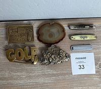 All items laid out showing belt buckles and pocket cutters together on wood surface