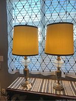 Pair of Paul Hanson table lamps illuminated, showing full height and lamp shades.