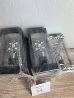 Six jeweled silver-tone wine stoppers with rhinestone decoration in clear plastic boxes and two metal zebra patterned wine stoppers.