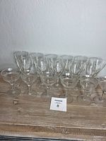 Front view showing all 17 glasses including both sets: 11 plain and 6 etched cordial glasses.