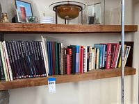 Bookshelf with various hardcover books including cookbooks and non-fiction books.