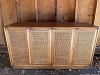 Front view of wooden sideboard showing four cane-panel doors and overall structure