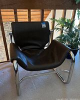 Front view of black leather sling chair on chrome frame