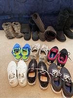 Overview of all 10 pairs of shoes laid out, including boots and athletic shoes.