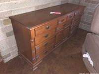 Full side and front view of the triple dresser showing drawer fronts, handles, and cabinet doors.