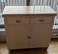 Front view of kitchen cart showing drawers, cabinets, hardware and wheels