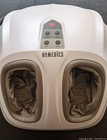 Top view of the foot massager showing two padded openings and control buttons for power, modes, and heat.