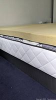 Side view of Therapedic memory foam topper on Sealy mattress and box spring