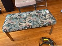 Full top-down view of the wood frame bench with floral fabric upholstery on cushioned top, showing entire seat and legs.