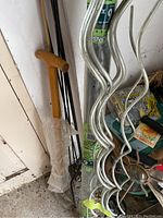 Photo showing bamboo stakes bundled in plastic next to metal stakes and tools.
