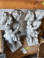 Front overview of both cherub statues on shelf