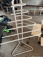 Front view of the metal towel rack showing the seven horizontal bars and triangular base.