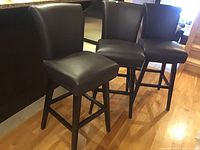 Three bar stools arranged side by side in kitchen setting