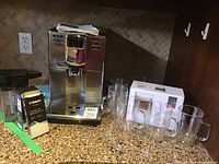 Saeco Incanto machine on countertop with loose and boxed glasses
