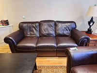 Front view showing full three seat brown leather couch