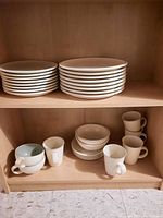 Top shelf with stacks of side plates and dinner plates.
