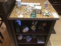 Overview of tabletop and shelf showing various figurines and collectibles including Swarovski bunnies, porcelain and crystal pieces