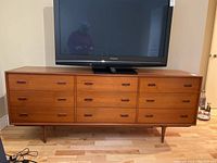 Full front view of teak dresser with TV on top