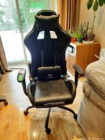 Front view of the black Vitesse office chair showing the overall shape, seat, backrest, armrests, and wheels.