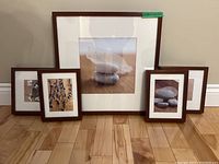All five framed prints arranged on floor