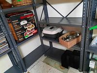 Shelf showing Nesco American Harvest dehydrator box, electric cooking pot, and vintage meat grinder.