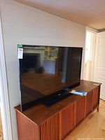Samsung 55" TV front view on wooden console
