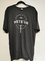 Grey Meteor t-shirt with circular 'MADE WITH METEOR' logo hanging on hanger against white background.