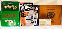 Photo showing six games including Greed, IQ Brain Train Game, Cribbage set, wooden chess set, and metal box game.