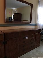Front and side view of large wood dresser with six drawers and cabinet doors, showing the finish and hardware.