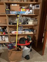 Wide view of shelving with electrical supplies including boxes of Philips light bulbs and the Ridgid wet/dry vacuum on the floor in front.