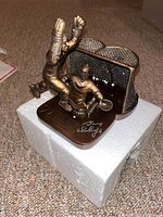 Bronze-tone figurine of Flyers player making a save in front of hockey net on white foam; autographed by Gary Dornhoefer on base