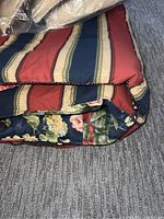 Close-up of reversible king size comforter showing striped pattern on one side and floral pattern on the other