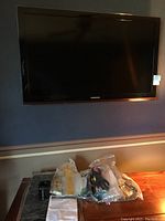 Samsung 39" TV mounted on the wall in turned off state, with visible Samsung branding at bottom center of bezel.