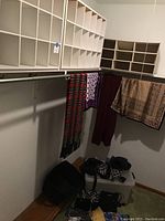 Two large wooden shoe cubbies installed above hanging rods with scarves and handbags underneath.