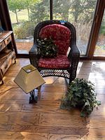 Full view showing wicker rocker chair, lamp on floor, faux ivy plant on floor