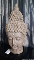 Front view of the resin Buddha head statue showing facial features and details of hair curls.