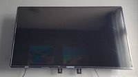 Front view of mounted Insignia TV showing screen and bezel