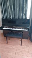 Front view of black lacquer upright piano with bench