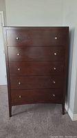 Front view of Shermag tall boy dresser showing 5 drawers and round metal knobs, wood with dark brown finish.