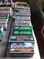 Rows of Hess toy trucks in original boxes laid out on a table.