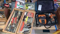 Overall view of tools and accessories including toolbox with bits and hand tools, Ryobi sander in storage bag, and Ridgid drill in black bag.